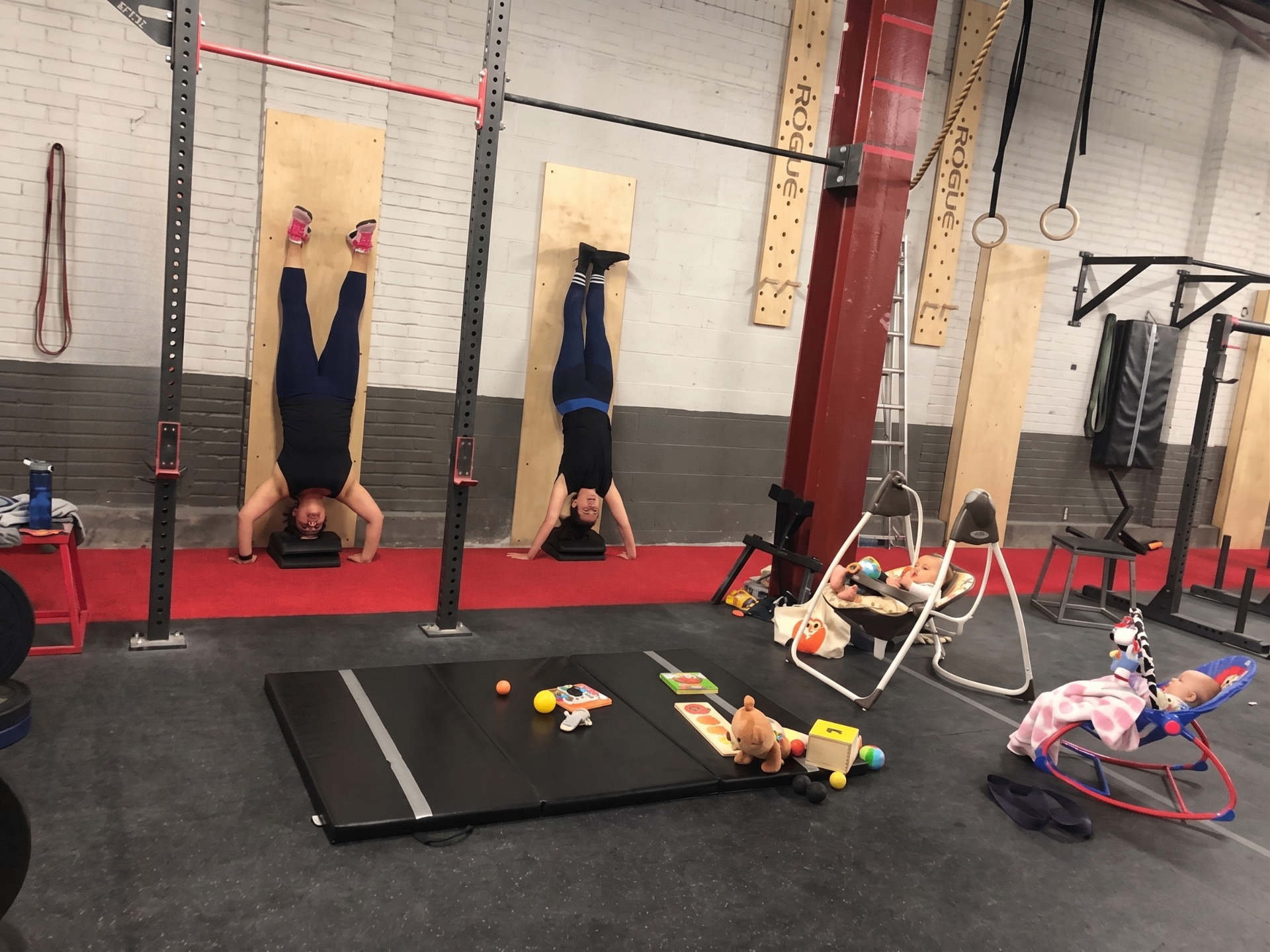 Parents faisant des handstands au mur avec bébés à côté